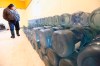 Stewart Redsky, former chief of Shoal Lake 40 First Nation, walks past one week's worth of 20 litre water bottles in the community's water storage room on Feb. 25, 2015. The First Nation is now welcoming clean, running water for the first time in nearly 25 years. THE CANADIAN PRESS/John Woods