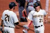 Pittsburgh Pirates' Bryan Reynolds, right, is greeted by Jacob Stallings after scoring on a sacrifice fly by Colin Moran during the third inning against the Cincinnati Reds in a baseball game in Pittsburgh, Wednesday, Sept. 15, 2021. All Pirates players wore No. 21 in honor of Roberto Clemente Day. (AP Photo/Gene J. Puskar)