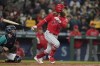 Los Angeles Angels' Brandon Marsh, right, and Seattle Mariners catcher Tom Murphy watch Marsh's two-RBI double in the third inning of a baseball game, Friday, Oct. 1, 2021, in Seattle. Luis Rengifo and David Fletcher scored on the play. (AP Photo/Ted S. Warren)