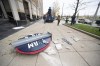 Workers from the Brilliant Electric Sign Company put out caution tape as pieces of the Cleveland Guardians team store sign lie on the ground in Cleveland, Friday, Nov. 19, 2021. The sign was being installed and fell off the building. (AP Photo/Ken Blaze)