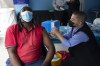 A man gets vaccinated against COVID-19 at a site near Johannesburg, Monday, Dec. 13, 2021 a day after South African President Cyril Ramaphosa tested positive receiving for mild COVID-19 symptoms after testing positive for the disease. Ramaphosa started feeling unwell Sunday and a test confirmed COVID-19. A statement said he has mild symptoms, is self-isolating in Cape Town and is being monitored by the South African Military Health Service. (AP Photo/Denis Farrell)