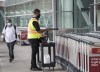 A man uses a sanitizer spray to wash down luggage carts at Toronto's Pearson International Airport&nbsp; in Toronto on Tuesday, June 23, 2020.&nbsp;Prime Minister Justin Trudeau says people will have to be careful as they finalize their Christmas plans this year, now that the highly transmissible Omicron variant is spreading through Canada. THE CANADIAN PRESS/Nathan Denette