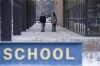 Students walk outside Roberto Clemente Community Academy in the Ukrainian Village neighborhood on the first day back to school, Wednesday, Jan. 12, 2022 in Chicago. Chicago schools will offer more COVID-19 testing and have standards to close school related to infection rates, but the cost of a bitter union battle and five days of missed schools has parents and union members questioning if it was worth it. (Pat Nabong/Chicago Sun-Times via AP)