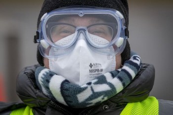 Dr. Lesley Seymour wears an N95 respirator during a drive-through COVID-19 vaccine clinic at St. Lawrence College in Kingston, Ont., Saturday, Dec. 18, 2021. THE CANADIAN PRESS/Lars Hagberg