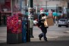 A Canada Post worker wearing a face mask to curb the spread of COVID-19 and a Santa hat while making deliveries in Vancouver, B.C., Thursday, Dec. 24, 2020. THE CANADIAN PRESS/Darryl Dyck