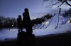 Julia Lindquist, 4, left, and Miles Stanton, 7, stand in silhouette on tree stumps and look over the five ski jump runs at the Norge Ski Club Tuesday, Jan. 18, 2022, in Fox River Grove, Ill. Lindquist was drawn to the sport when her parents would drive around the area for something safe to do during the COVID-19 pandemic last year. Each time the family of four drove near the club last year, the little girl in the back of the car told her parents of her hopes and dreams. 