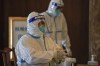 Medical workers wearing protective gear prepares swabs for people taking part in the Beijing Winter Olympics torch relay activities at a coronavirus test site in Beijing, Wednesday, Feb. 2, 2022. With more than 30 new COVID-19 cases being detected daily ahead of the Beijing Olympics, organizers said Wednesday they aren't worried and expect numbers to drop within days. (AP Photo/Andy Wong)