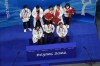 Jin Boyang, of China, front center, waits to receive his score after performing during the men's singles short program team event in the figure skating competition at the 2022 Winter Olympics, Friday, Feb. 4, 2022, in Beijing. (AP Photo/Jeff Roberson)