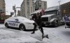 A protester shovels snow from around police and truck vehicles, Thursday, Feb. 3, 2022 in Ottawa. THE CANADIAN PRESS/Adrian Wyld