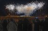 Children play as they wait in a neighbouring carpark to catch a glimpse of the fireworks for the opening ceremony of the 2022 Winter Olympics, Friday, Feb. 4, 2022, in Beijing. (AP Photo/Ng Han Guan)