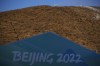 A snow making machine blows snow on a hill overlooking cross-country skiing practice before the 2022 Winter Olympics, Wednesday, Feb. 2, 2022, in Zhangjiakou, China. (AP Photo/Aaron Favila)