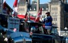 A protester affixes a flag to the top of their truck, parked beside a truck with a sign calling for the jailing of Prime Minister Justin Trudeau, outside Parliament Hill, as a protest against COVID-19 restrictions continues into its second week in Ottawa on Monday, Feb. 7, 2022. Conservatives appear increasingly split over whether a protest against COVID-19 health restrictions that's well its second week in the nation's capital should stay or go. THE CANADIAN PRESS/Justin Tang