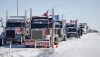 A truck convoy of anti-COVID-19 vaccine mandate demonstrators block the highway at the busy U.S. border crossing in Coutts, Alta., Wednesday, Feb. 2, 2022. The province's vaccine passport is gone but protesters are vowing to hunker down for the long term on the highway leading to the main border crossing in Alberta. THE CANADIAN PRESS/Jeff McIntosh