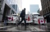 A person walks past trucks parked on a street in downtown Ottawa on Wednesday, Feb. 2, 2022 in Ottawa. THE CANADIAN PRESS/Adrian Wyld