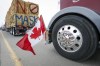 The Canadian flag is reflected in a wheel hub as demonstrators against a vaccine mandate for truckers and other pandemic restrictions gather in a truck convoy blocking the highway at the busy U.S. border crossing near Coutts, Alta., on Monday, Jan. 31, 2022. THE CANADIAN PRESS/Jeff McIntosh