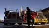 A man walks past trucks parked in front of the Parliament buildings, Tuesday, Feb. 15, 2022 in Ottawa. THE CANADIAN PRESS/Adrian Wyld