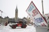 Machinery moves a concrete barricade past the Parliament buildings and a container of garbage from the Trucker protest which has occupied the streets of Ottawa, Sunday, February 20, 2022. THE CANADIAN PRESS/Adrian Wyld