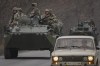 Ukrainian servicemen sit atop armored personnel carriers driving on a road in the Donetsk region, eastern Ukraine, Thursday, Feb. 24, 2022. Russian President Vladimir Putin on Thursday announced a military operation in Ukraine and warned other countries that any attempt to interfere with the Russian action would lead to 