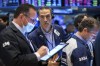 In this photo provided by the New York Stock Exchange, Gregory Rowe, center, works with fellow traders work on the floor, Thursday, Feb. 24, 2022. Markets shuddered worldwide Thursday and swung sharply after Russia's invasion of Ukraine threatened to push the high inflation squeezing the global economy even higher. (Courtney Crow/New York Stock Exchange via AP)