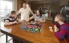 Nolan Balcitis, left, plays the board game Monopoly with his family at their home in Crown Point, Ind., on March 5, 2022. From left are Nolan, Bryan, Tabitha and Colin Balcitis. Nolan was diagnosed with Type 1 diabetes six months after a mild case of COVID-19. Reports of rising diabetes cases during the pandemic have scientists exploring if there could be a link with the coronavirus. Emerging evidence shows the virus can attack insulin-producing cells in the pancreas, a process that might trigger diabetes in susceptible people. (AP Photo/Teresa Crawford)