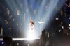 Seven-year-old Amellia Anisovych, a refugee from Ukraine, center, sings the Ukraine national anthem at the start of a fund-raising concert in Lodz, Poland, Sunday, March 20, 2022. Anisovych became widely known for singing a song from the movie Frozen in a bomb shelter in Kyiv in early March. She has since come to Poland with her grandmother and brother. Her parents remained in Kyiv. (AP Photo/Marian Zubrzycki)