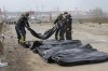 Ukrainian soldiers collect bodies of civilians killed by the Russian forces at the destroyed bridge in Irpin close to Kyiv, Ukraine, Thursday, March 31, 2022. The more than month-old war has killed thousands and driven more than 10 million Ukrainians from their homes including almost 4 million from their country. (AP Photo/Efrem Lukatsky)