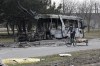 A woman rides a bicycle past a burned bus after fighting on the outskirts of Mariupol, Ukraine, in territory under control of the separatist government of the Donetsk People's Republic, on Tuesday, March 29, 2022. International Development Minister Harjit Sajjan and Public Safety Minister Marco Mendicino discuss the International Criminal Court investigation into alleged war crimes by Russia. (AP Photo/Alexei Alexandrov)