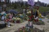 Tetiana Rurak, 25-year-old widow Oleksandra Rurak, visits her soldier husband Volodymyr Rurak's, grave with her one and a half year old daughter, after he was killed in action, at the Lychakiv cemetery, in Lviv, western Ukraine, Tuesday, April 5, 2022. (AP Photo/Nariman El-Mofty)