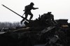 A Ukrainian serviceman walks on a destroyed Russian fighting vehicle in Bucha, Ukraine, Thursday, April 7, 2022. Russian troops left behind crushed buildings, streets littered with destroyed cars and residents in dire need of food and other aid in a northern Ukrainian city, giving fuel to Kyiv's calls Thursday for more Western support to help halt Moscow's offensive before it refocuses on the country's east. (AP Photo/Vadim Ghirda)