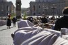 People wait for the arrival of Pope Francis to celebrate Palm Sunday Mass in St. Peter's Square at the Vatican, Sunday, April 10, 2022. The Roman Catholic Church enters Holy Week, retracing the story of the crucifixion of Jesus and his resurrection three days later on Easter Sunday. (AP Photo/Gregorio Borgia)