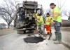 RUTH BONNEVILLE / WINNIPEG FREE PRESS
City crews fill potholes with a tar mixture along Burrows Ave. on Thursday afternoon.