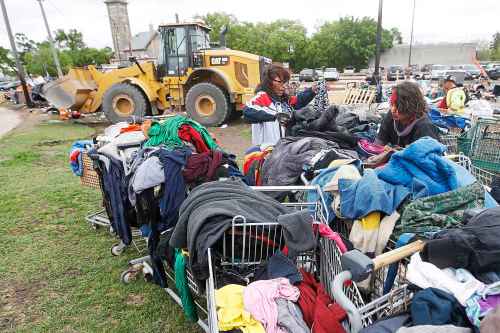 JOHN WOODS / WINNIPEG FREE PRESS
Desirae, right, and another resident look through carts of clothing as city crews dismantle camps on Austin Street and Henry Avenue in downtown Winnipeg in June.