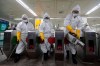 Workers wearing protective gears spray disinfectant as a precaution against the new coronavirus at a subway station in Seoul, South Korea, Friday, Feb. 28, 2020. Japan's schools prepared to close for almost a month and entertainers, topped by K-pop superstars BTS, canceled events as a virus epidemic extended its spread through Asia into Europe and on Friday, into sub-Saharan Africa. (AP Photo/Ahn Young-joon)