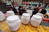 Workers unload canisters of disinfectant from a truck in Wuhan in central China's Hubei Province, Tuesday, Jan. 28, 2020. Hong Kong's leader announced Tuesday that all rail links to mainland China will be cut starting Friday as fears grow about the spread of a new virus. (Chinatopix via AP)