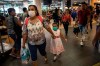 Wearing masks, passenger Gladys Ruiz Torres walks with her daughter Natali Oliva to the departure lounge at the international airport in Lima, Peru, Friday, March 6, 2020. Peruvian President Martin Vizcarra announced the first case of the new coronavirus in the country. (AP Photo/Rodrigo Abd)