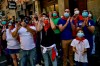 FILE In this Saturday, June 20, 2020 file photo, residents wear faces mask to protect against coronavirus and wear San Fermin's red kerchief as people march the route of the running of the bulls while a singer performs a San Fermin's festival song, in Pamplona, northern Spain. Spain reopened its borders to European tourists Sunday, June 21, 2020 in a bid to kickstart its economy while Brazil and South Africa struggled with rising coronavirus infections. At a campaign rally, President Donald Trump said he told the U.S. government to reduce testing for the virus, apparently to avoid unflattering statistics ahead of the U.S. election in November. (AP Photo/Alvaro Barrientos, File)