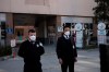 Security officials stand at the entrance of Zekai Tahir Burak Hospital where 17 passengers of a Turkish Airlines flight from Tehran, suspected of having coronavirus, were to be quarantined, in Ankara, Turkey, Tuesday, Feb. 25, 2020. All 132 passengers of Tehran-Istanbul flight and crew on board will be quarantined for 14 days at the same hospital where Turkish citizens returning from China had been quarantined.( AP Photo/Burhan Ozbilici)