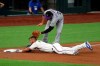 Texas Rangers' Jeff Mathis, bottom, slides into third ahead of the tag by Colorado Rockies third baseman Nolan Arenado (28) in the third inning of a baseball game Saturday, July 25, 2020, in Arlington, Texas. (AP Photo/Richard W. Rodriguez)