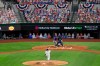 Texas Rangers starter Lance Lynn (35) throws the first pitch of an opening day baseball game to Colorado Rockies' David Dahl as Rangers' Robinson Chirinos catches and home plate umpire Jim Reynolds looks on Friday, July 24, 2020, in Arlington, Texas. The pitch was the first ever in a regular season game at Globe Life Field, the Rangers' new ballpark. (AP Photo/Jeffrey McWhorter)