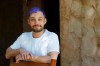 In this Monday, March 30, 2020, photo Luke Blaine stands at the front entrance of his home in Phoenix. Blaine, 30, a bartender at Fez, a popular restaurant in downtown Phoenix, was laid off with the rest of the staff when the business shut completely to follow Arizona‚Äôs state precautions amid the pandemic. Blaine said he was blessed to have been taught the value of a dollar by his parents and was entering unemployment without any debt. (AP Photo/Ross D. Franklin)