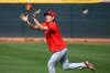 Cincinnati Reds center fielder Shogo Akiyama, of Japan, reaches up to catch a football as outfielders warm up during spring training baseball workouts Friday, Feb. 21, 2020, in Goodyear, Ariz. (AP Photo/Ross D. Franklin)