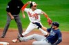 Baltimore Orioles shortstop Andrew Velazquez (13) forces out Tampa Bay Rays' Austin Meadows, bottom, at second base on a ball hit by Joey Wendle during the second inning of a baseball game, Thursday, Sept. 17, 2020, in Baltimore. (AP Photo/Julio Cortez)