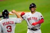 Boston Red Sox's Rafael Devers, right, is greeted near home plate by Jose Peraza (3) after Devers hit a three-run home run off Baltimore Orioles relief pitcher Jorge Lopez during the fifth inning of a baseball game, Friday, Aug. 21, 2020, in Baltimore. Red Sox's Kevin Pillar, not visible, and Peraza scored on the home run. (AP Photo/Julio Cortez)