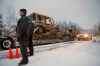 RCMP officers look on as contractors pass through their roadblock as supporters of the Unist'ot'en camp and Wet'suwet'en First Nation gather at a campfire off a logging road near Houston, B.C., in January 2019. (Chad Hipolito / Canadian Press files)