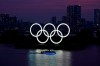 FILE - In this June 3, 2020, photo, the Olympic rings float in the water at sunset in the Odaiba section in Tokyo. The Japanese public is being prepared for the reality of next year's postponed Olympics where athletes are likely to face quarantines, spectators will be fewer, and the delay will cost taxpayers billions of dollars. In the last several weeks, IOC President Thomas Bach has given selected interviews outside Japan and hinted at empty stadiums, quarantines and virus testing. (AP Photo/Eugene Hoshiko, File)