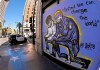 A mural is seen on a boarded up business as a Los Angeles Police Department car drives by, Tuesday, June 9, 2020, in the Hollywood section of Los Angeles. Many businesses were boarded up during protests over the death of George Floyd. Floyd, a black man died after being restrained by Minneapolis police officers on May 25. (AP Photo/Mark J. Terrill)