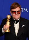 Elton John poses in the press room with the award for best original score in a motion picture for 