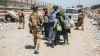 In this photo provided by the U.S. Marine Corps, Italian coalition forces assist and escort evacuees for onward processing during an evacuation at Hamid Karzai International Airport in Kabul, Afghanistan on Tuesday. (Staff Sgt. Victor Mancilla/U.S. Marine Corps/The Associated Press)