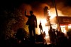 Protesters gather in front of a burning fast food restaurant Friday, May 29, 2020, in Minneapolis. Protests over the death of George Floyd, a black man who died in police custody Monday, broke out in Minneapolis for a third straight night. (AP Photo/John Minchillo)