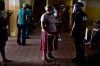 People wait in line to vote during the general election at a voting center set up at the Manuel Gaetan Barbosa School in San Juan, Puerto Rico, Tuesday, Nov. 3, 2020. In addition to electing a governor, Puerto Ricans are voting in a non-binding referendum on statehood. (AP Photo/Carlos Giusti)